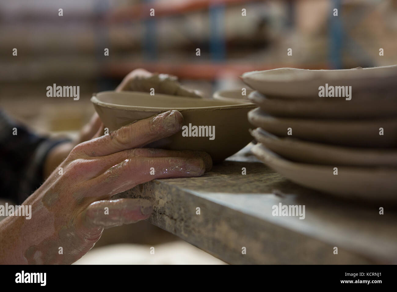 Machos mano alfareros examinando una cazoleta en el taller de cerámica artesanal Foto de stock