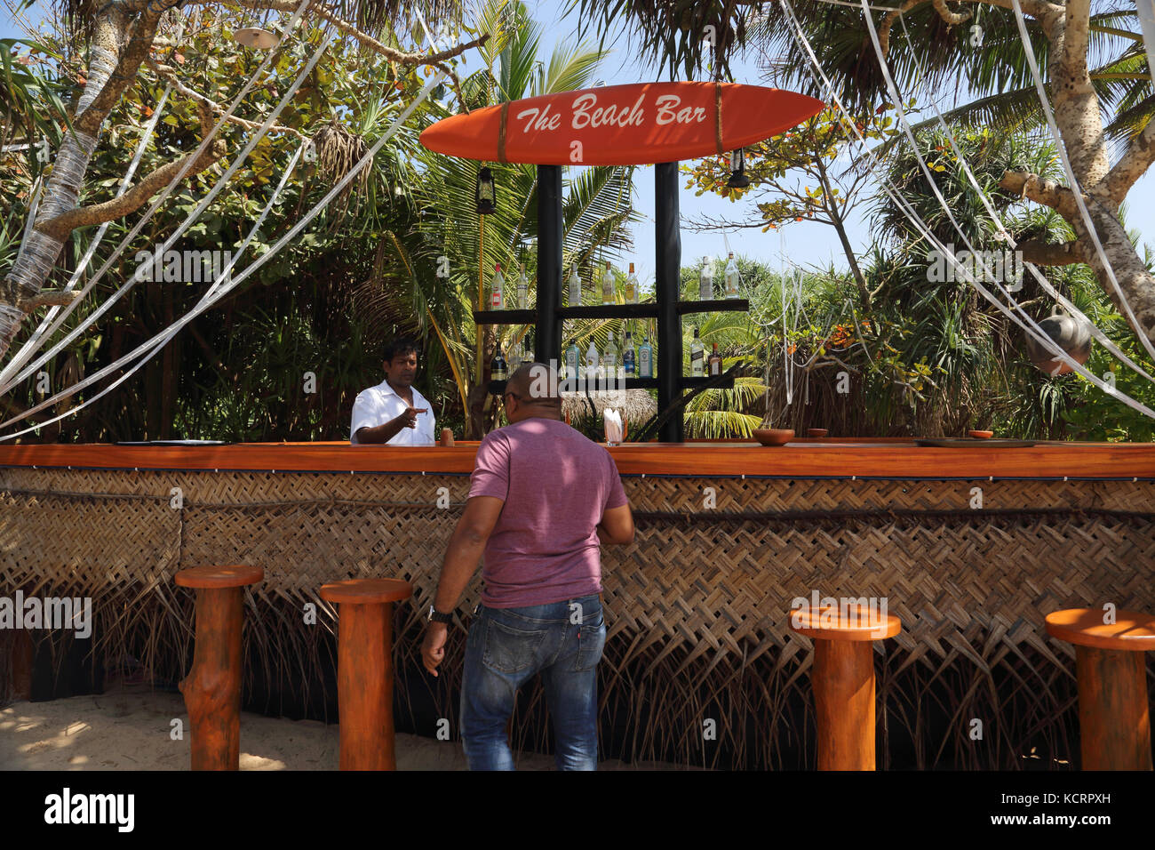 Bentota Sri Lanka Amal Villa Restaurante y Bar el hombre se sirve en el bar de la playa Foto de stock