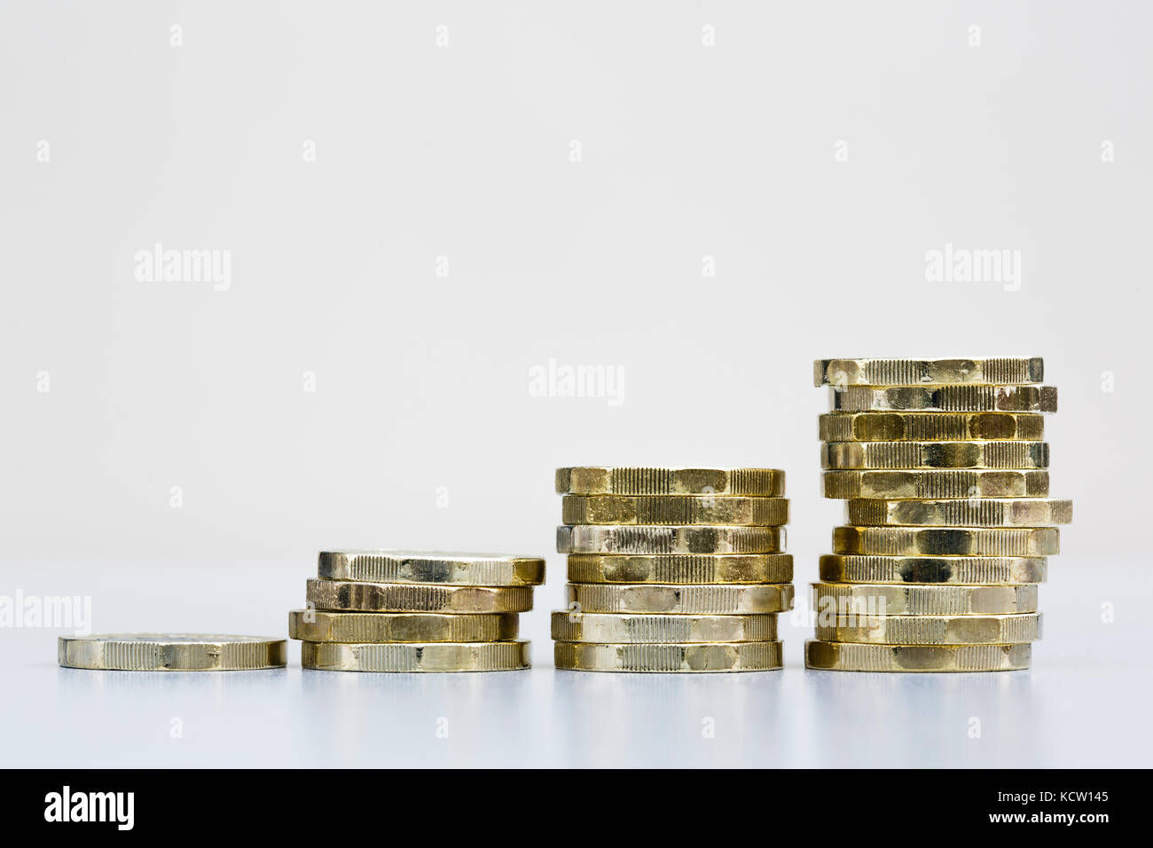 Montón de dinero británico libras esterlinas nuevas monedas de una libra dinero en efectivo GBP en cuatro pilas Ahorra ahorros crecimiento crecimiento concepto de crecimiento financiero Inglaterra Reino Unido Gran Bretaña Foto de stock
