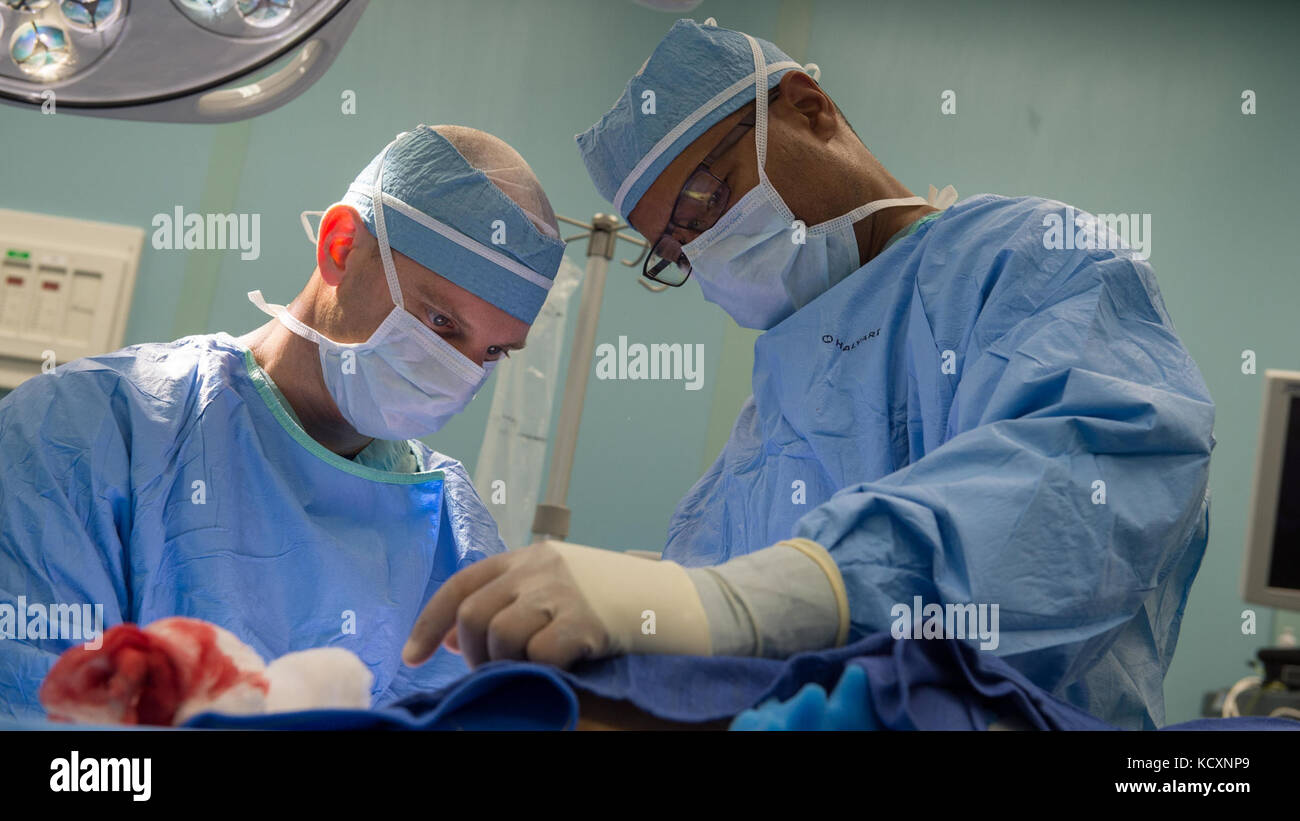 171006-N-MU198-089 MAR CARIBE (Oct. 6, 2017) Cmdr. Matt Bradley (izquierda)  y Cmdr. Elliot Jessie realice una operación quirúrgica se celebró en una  sala de operaciones a bordo del barco hospital USNS Comfort (