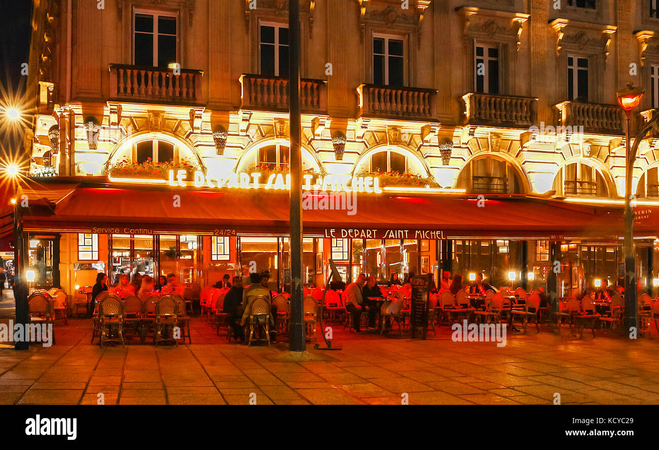 El tradicional café francés le sale de Saint Michel por la noche, París, Francia. Foto de stock