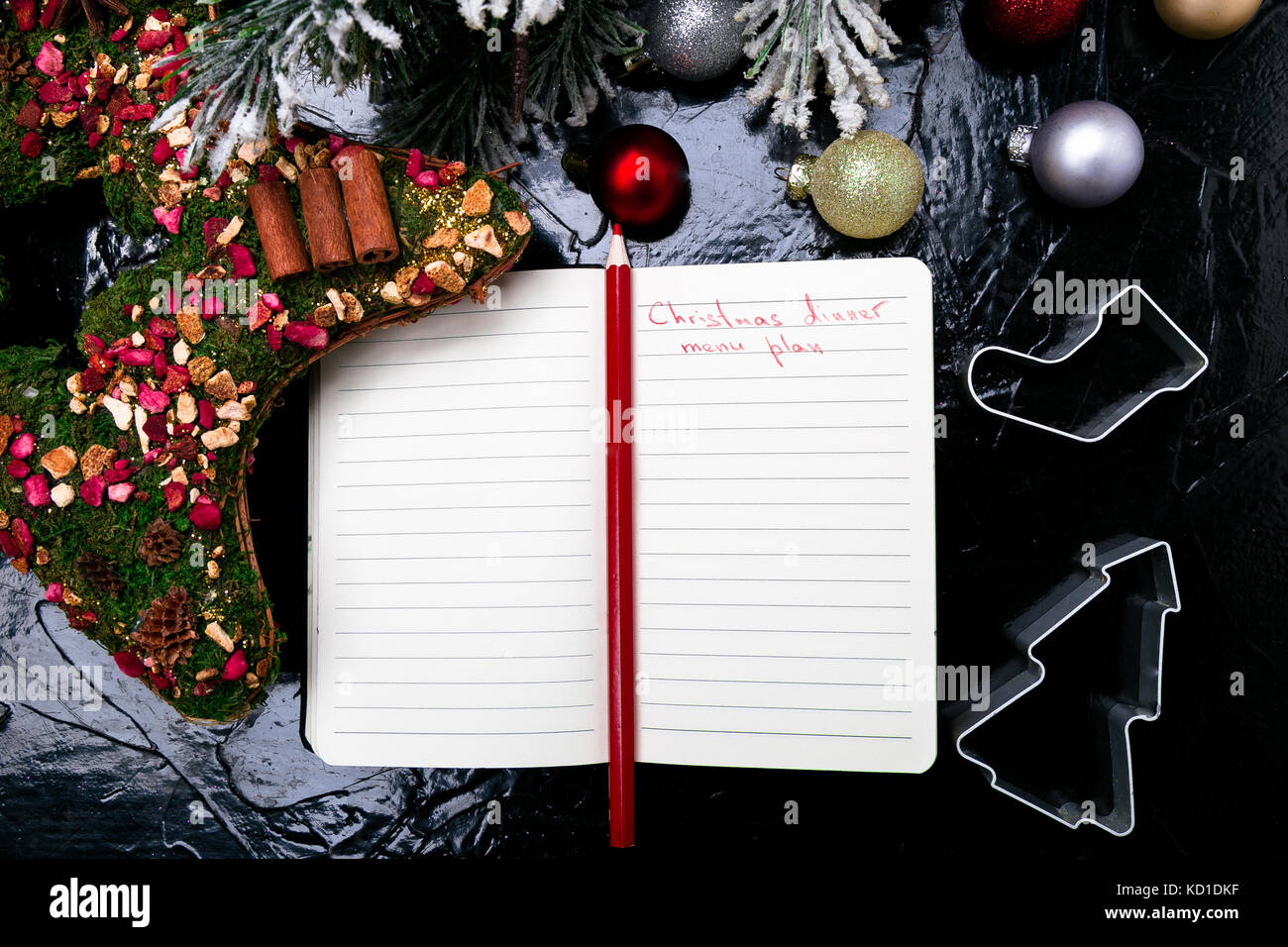 Menú navideño plan. fondo para escribir el menú navideño. vista desde arriba. cuaderno sobre fondo negro con decoración Foto de stock