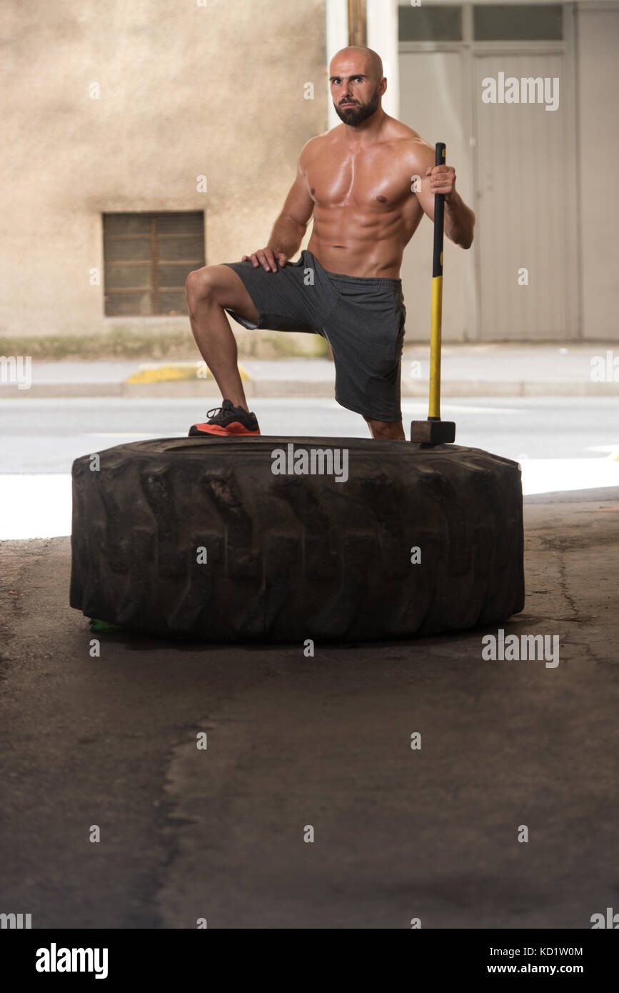 Entrenamiento Crossfit - hombre volteando neumático en gimnasio Fotografía  de stock - Alamy