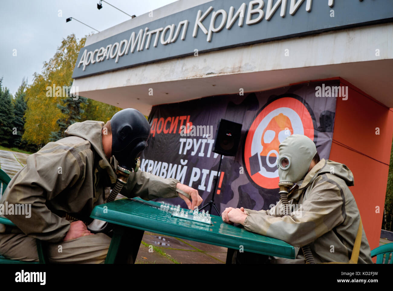 Kryvyi rih, Ucrania - Octubre 9, 2017: dos hombres con máscaras de gas en las caras jugar ajedrez cerca de arcelormittal kryvyi rih pjsc monumento marca en reunión de la protesta contra la contaminación del aire de crédito: dmytro aliokhin/alamy live news Foto de stock