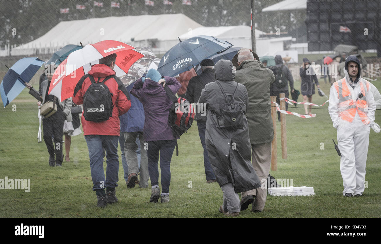 Los espectadores, en un día de lluvia hacen su camino a través de la pista de aterrizaje a la lavant directamente en el 2017 goodwood revival, Sussex, Reino Unido. Foto de stock