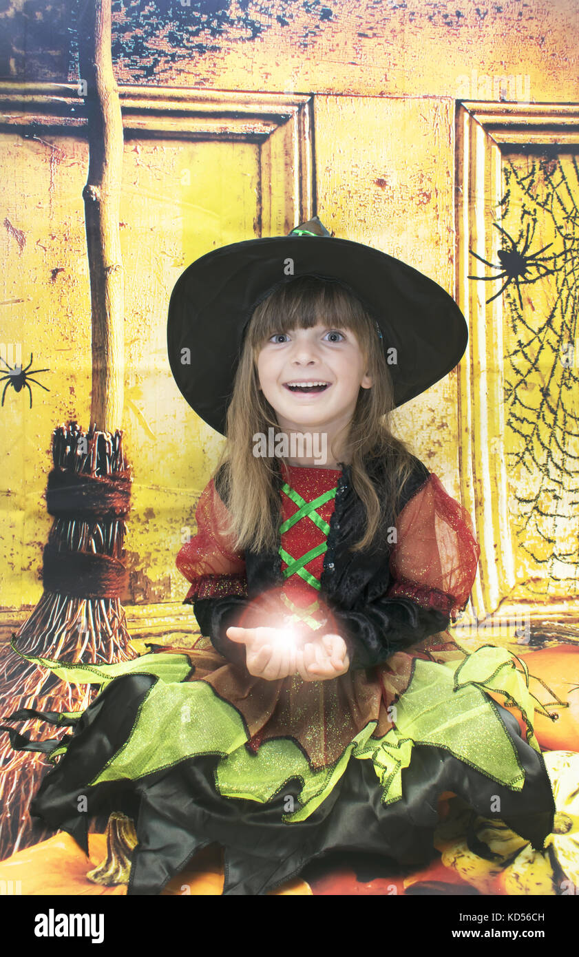 Adorable niña en halloween tiempo. Ella es de cinco años y la celebración de una bola de luz mágica. Foto de stock