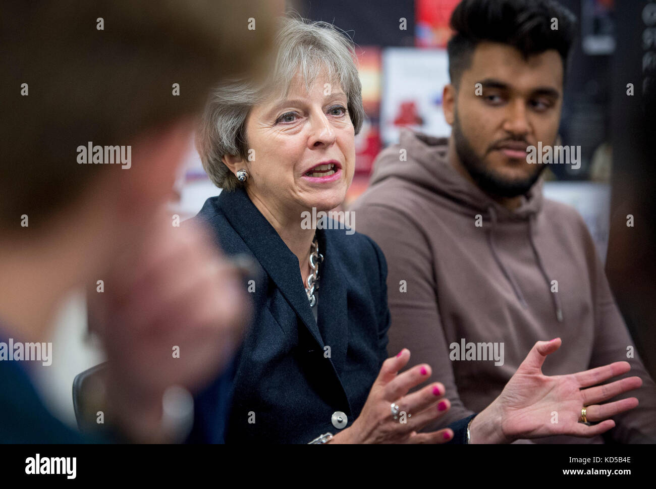 La primera Ministra Theresa May habla con el personal y los alumnos durante una visita a la Escuela Dunraven en Streatham, al sur de Londres, antes de la publicación de los detalles de la Auditoría de la disparidad racial del Gobierno. Foto de stock