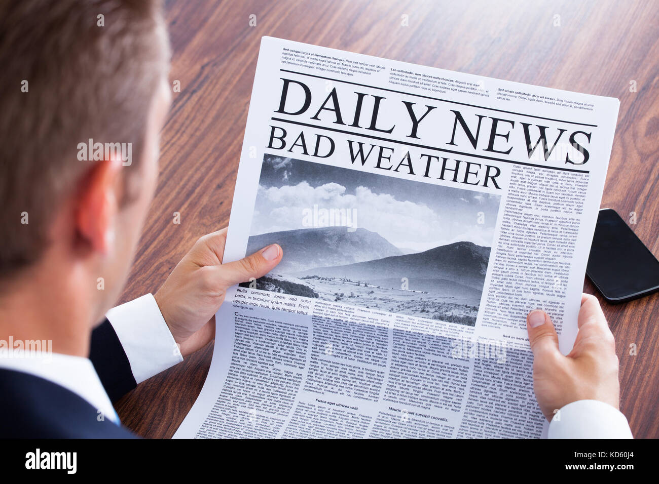 Cerca del empresario leyendo noticias meteorológicas en periódicos Foto de stock