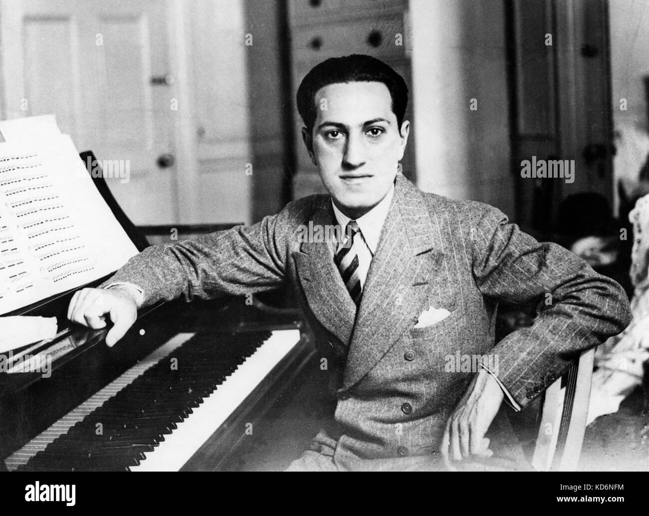 George Gershwin - retrato inclinado sobre el piano con Abrir página de la partitura. . El compositor y pianista estadounidense el 26 de septiembre de 1898 - 11 de julio de 1937 Foto de stock