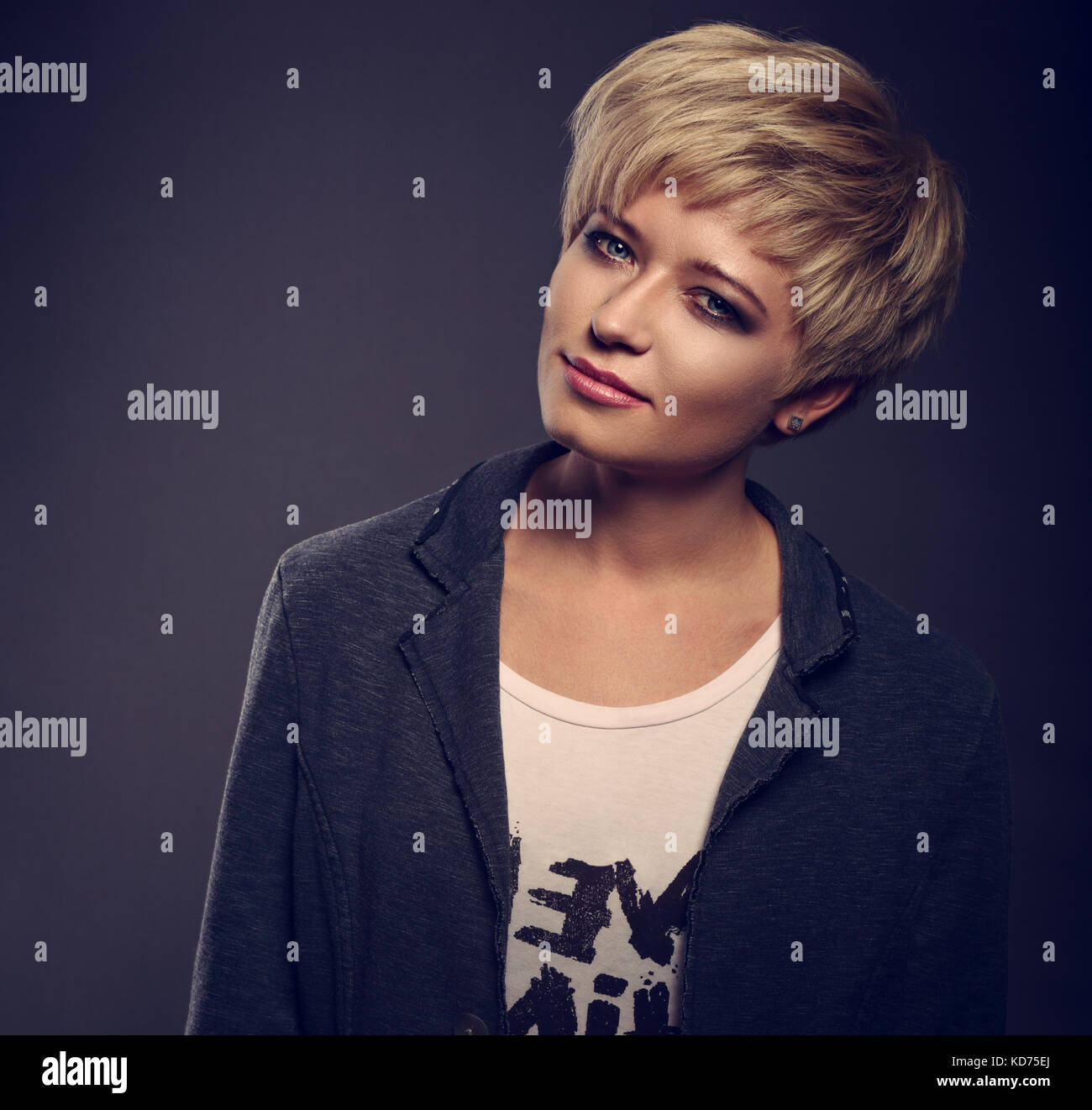 Feliz Sonriente Joven Mujer Rubia Con Estilo De Pelo Corto Bob Busca En Gris Sobre Fondo Oscuro Chaqueta De Moda Closeup Retrato De Tonos Fotografia De Stock Alamy