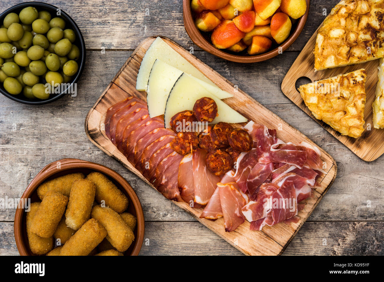 Las tradicionales tapas españolas. croquetas, aceitunas, tortilla, jamón, patatas bravas en mesa de madera Foto de stock