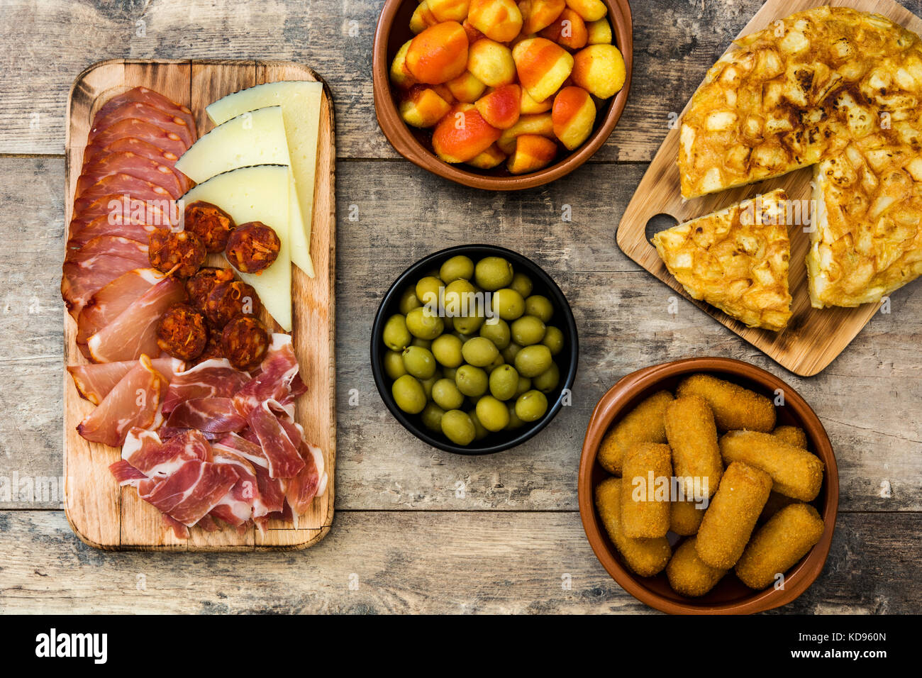 Las tradicionales tapas españolas. croquetas, aceitunas, tortilla, jamón, patatas bravas en mesa de madera Foto de stock