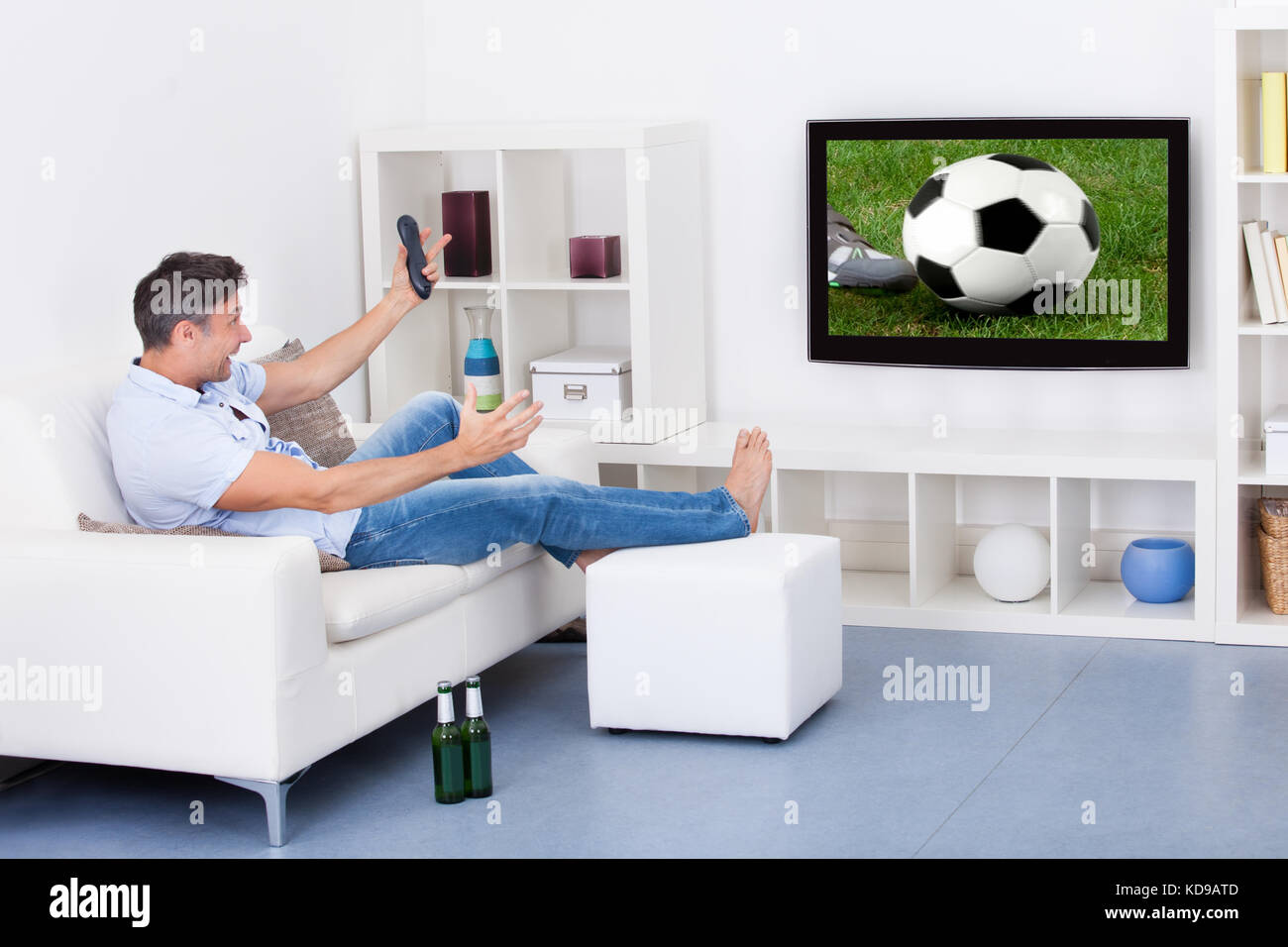 Retrato de un hombre maduro entusiasmados viendo partido de fútbol en la televisión Foto de stock