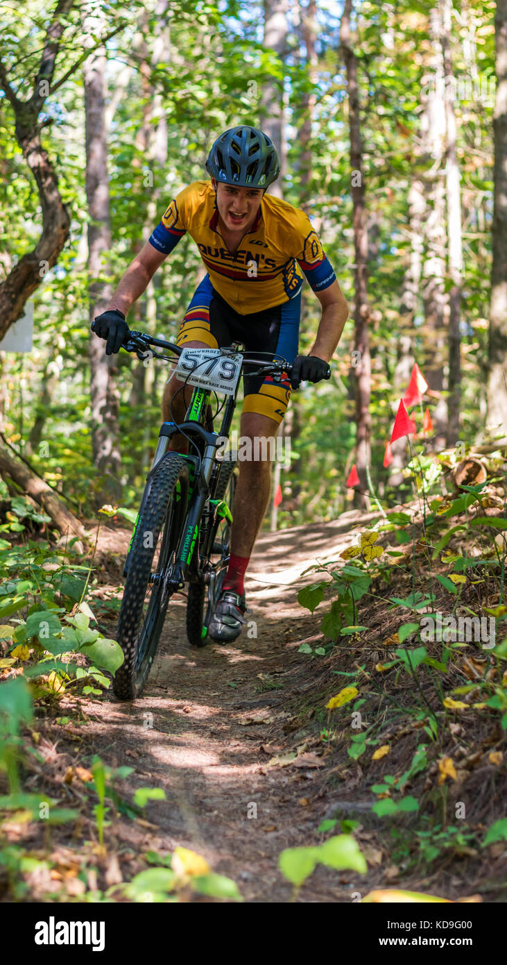 Ganaraska bosque, región de Durham, Ontario, Canadá - Septiembre 24, 2017: un jinete en la universidad carrera de mountain bike cup series negocia una colina. Foto de stock