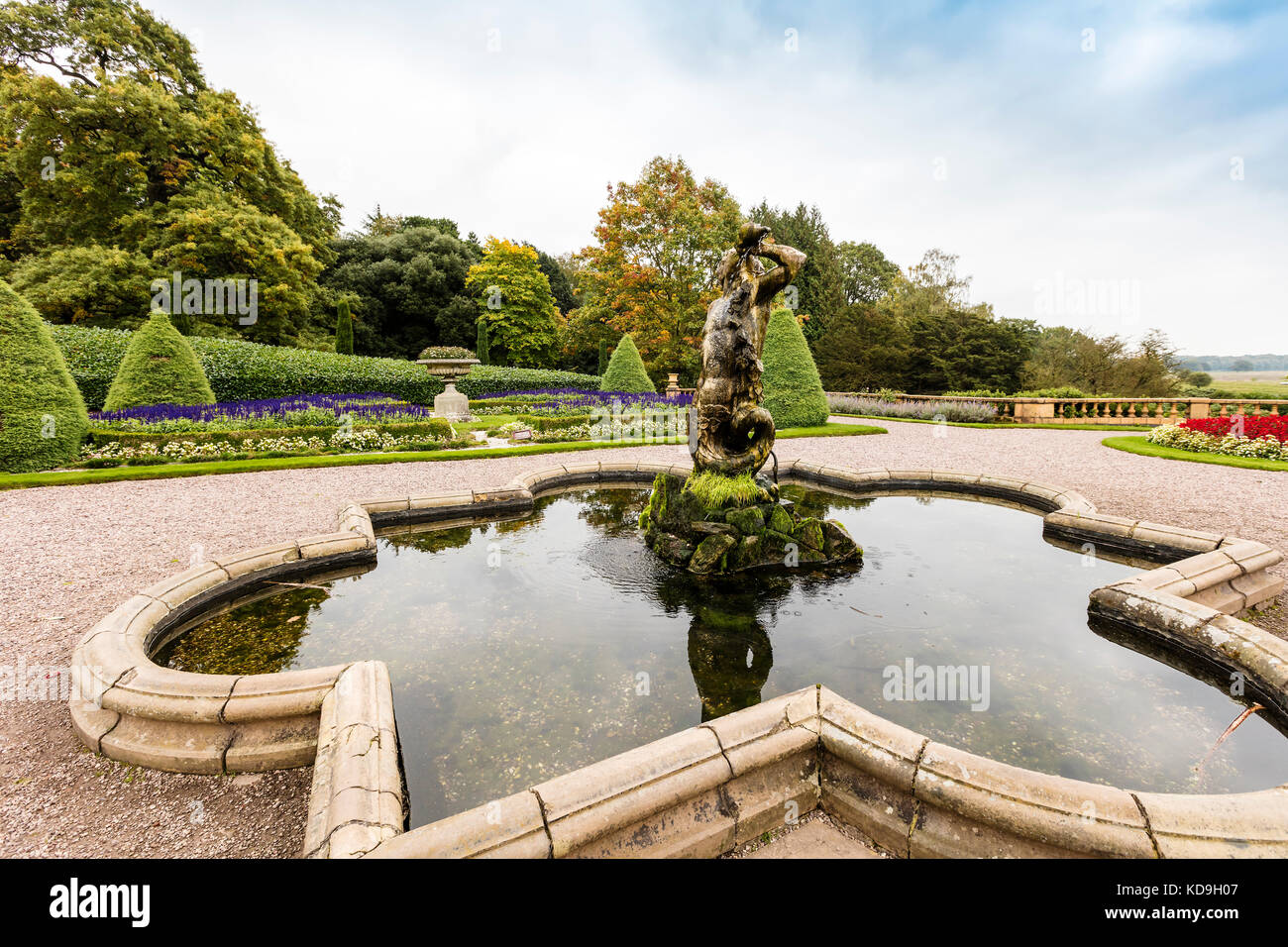 Escultura antigua fuente del Tritón (también conocido como Neptuno) en los jardines de un parque histórico en Cheshire, Reino Unido. Foto de stock