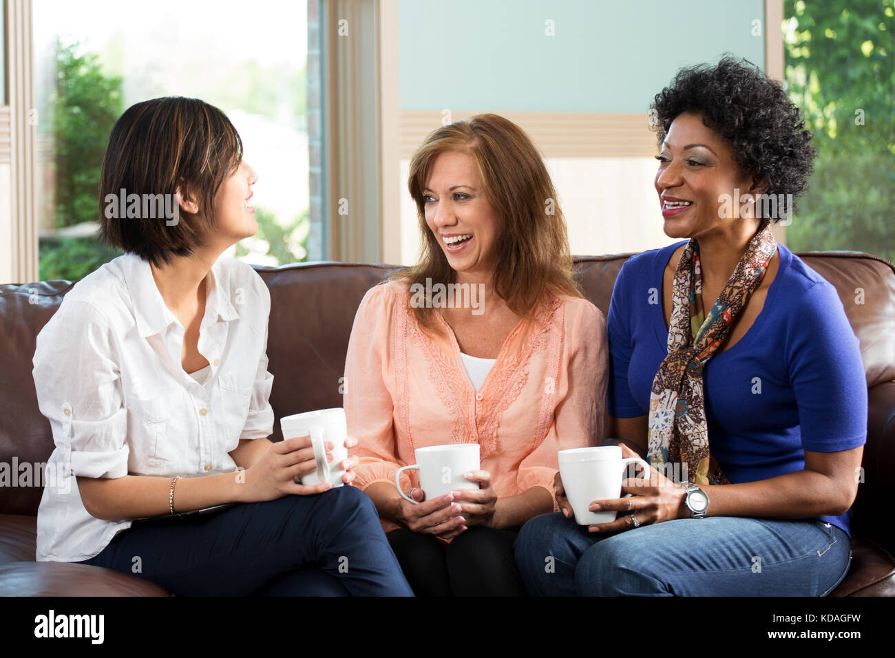 Diversos grupos de amigos hablando y riéndose. Foto de stock