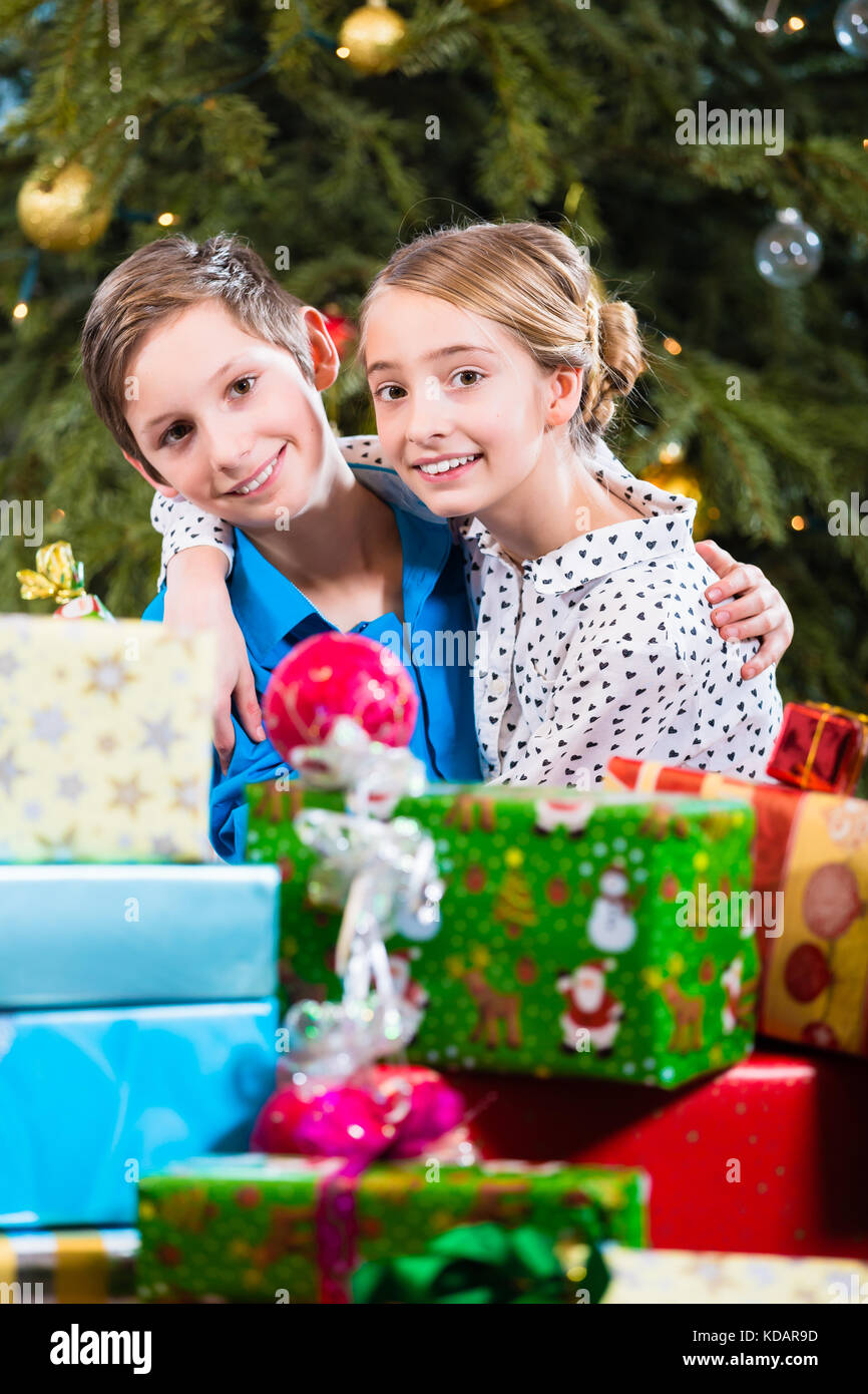 Hermano y hermana durante la entrega de regalos, deseando feliz Foto de stock