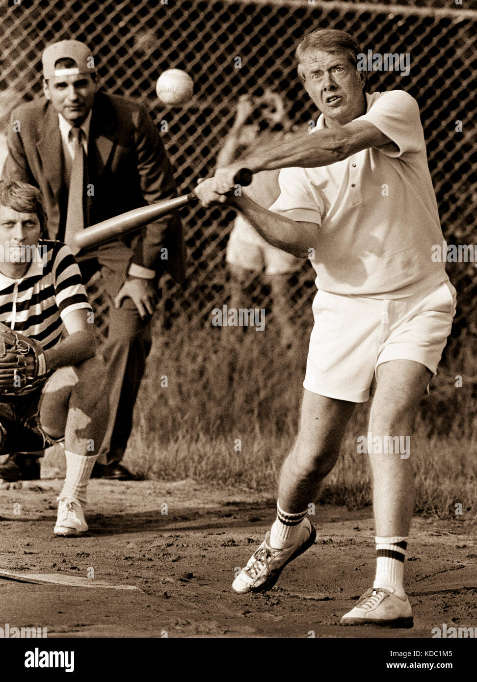 Carter al bate durante un juego de softbol en Plains High School. El árbitro es el defensor del consumidor y futuro candidato presidencial cinco veces Ralph Nader. Foto de stock