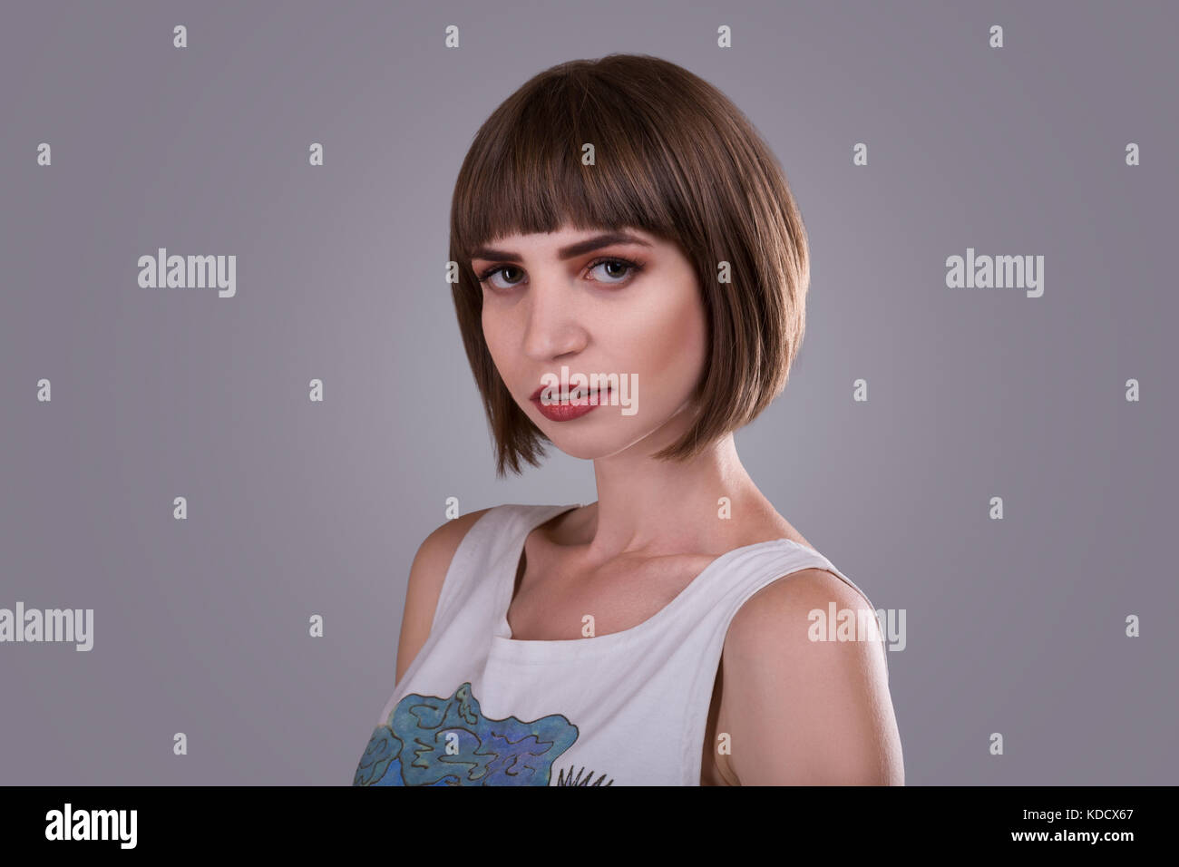 Mujer Joven Con Cabello Corto Morena Contra El Gris De Fondo De Estudio Corte De Pelo Corto Fotografia De Stock Alamy