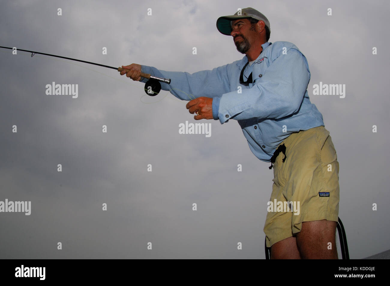 Un pescador arroja una caña de mosca de la gallineta, mientras que la pesca en los planos superficiales de la Laguna Madre, en el sur de Texas Foto de stock