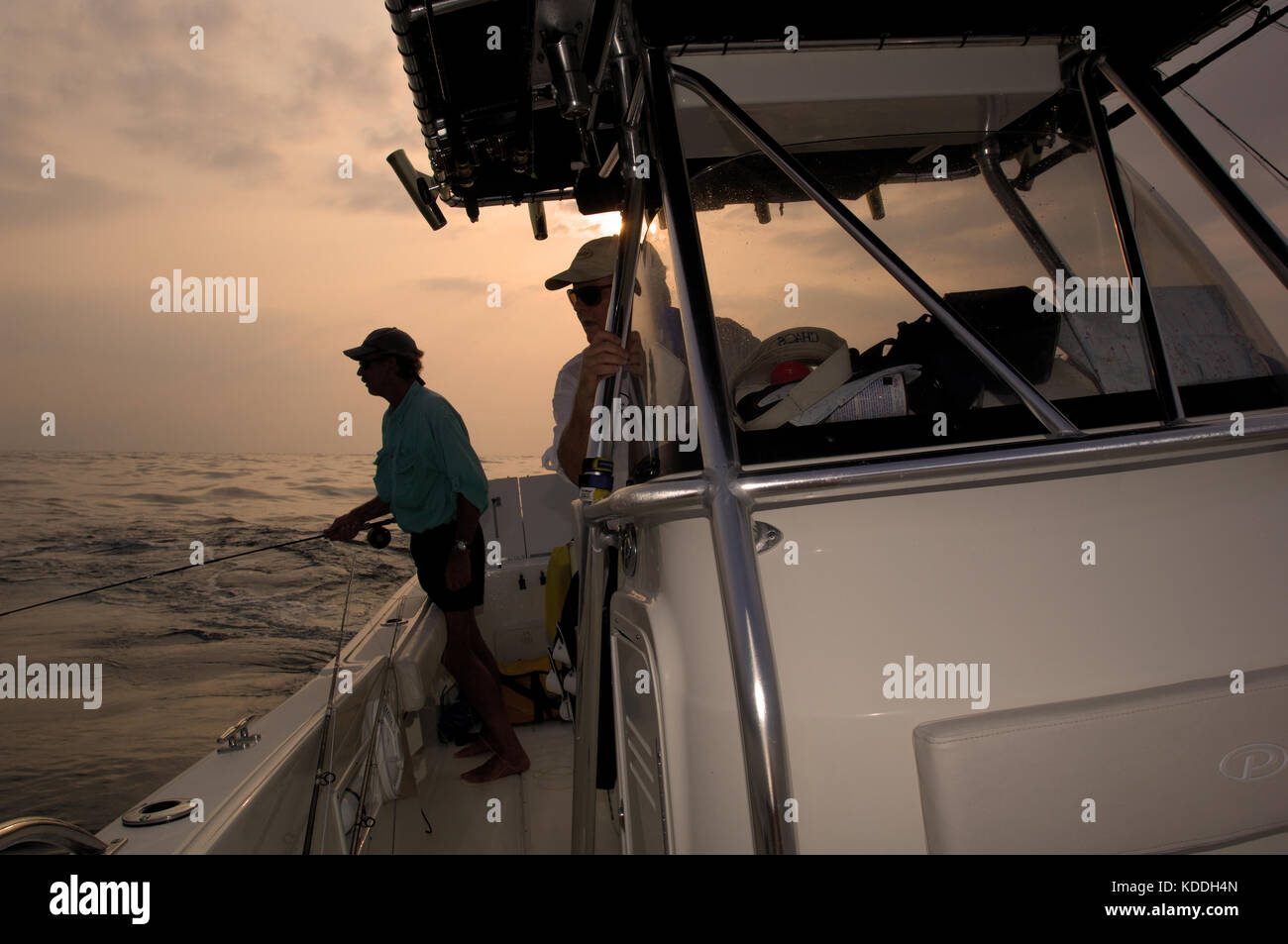 Un pescador con mosca proyectando su caña de mosca y busca carite en una línea de malezas offshore de Freeport Texas Foto de stock