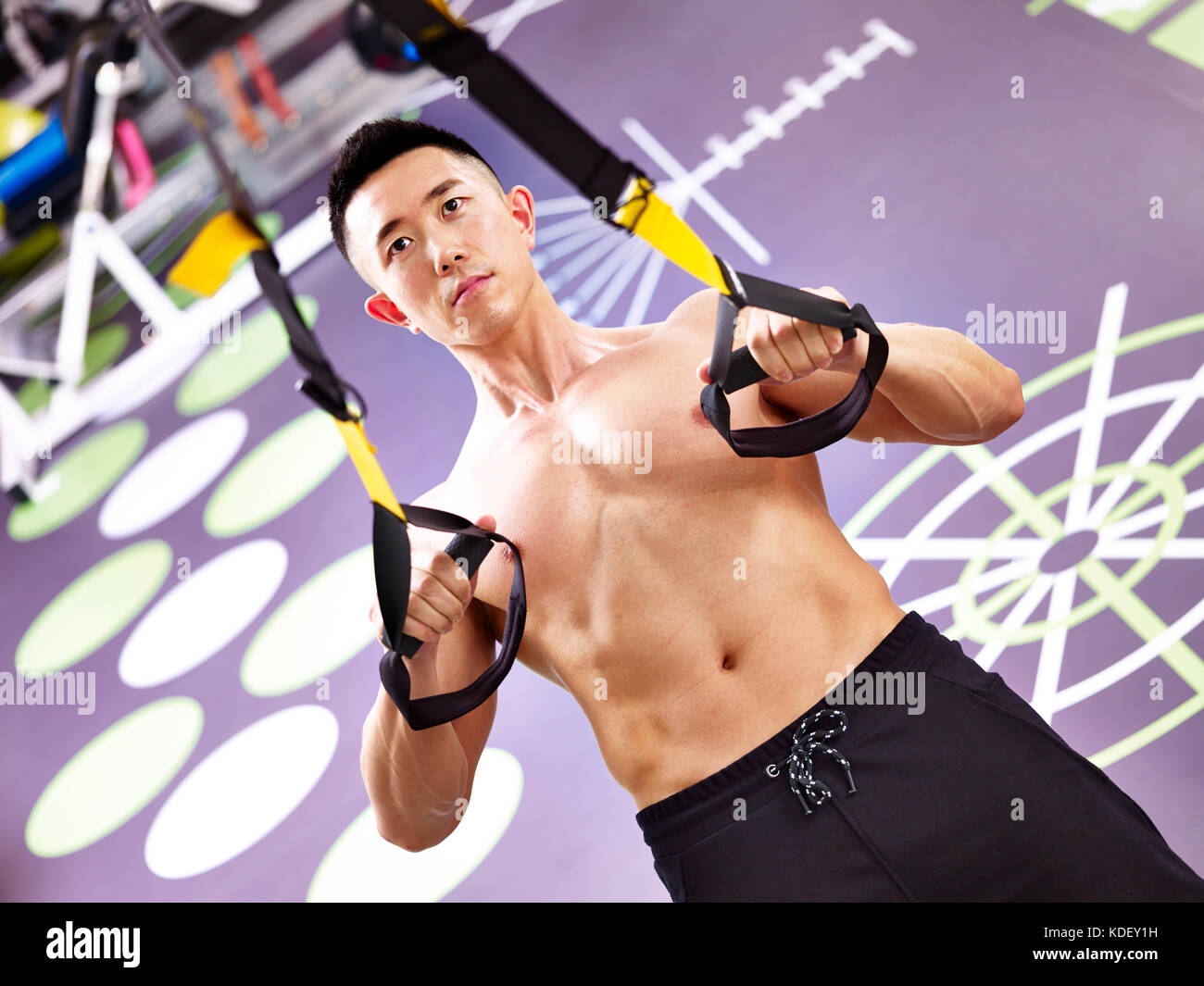 Culturista asiáticos trabajando en el gimnasio Fitness mediante correas. Foto de stock