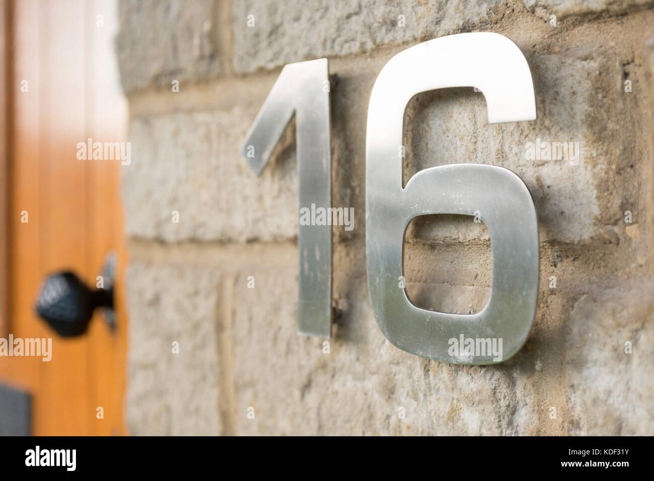 Acero inoxidable números organizados para mostrar el número 16 pegada a la  pared exterior de ladrillos de una casa. La identificación de su dirección  Fotografía de stock - Alamy