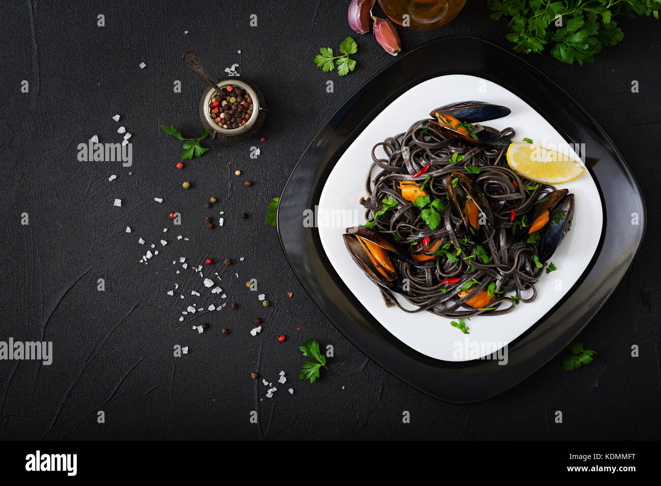 Espaguetis. negro negro pasta con marisco mejillones sobre fondo negro. delicadeza mediterránea alimentos. plana vista superior de la lay. Foto de stock