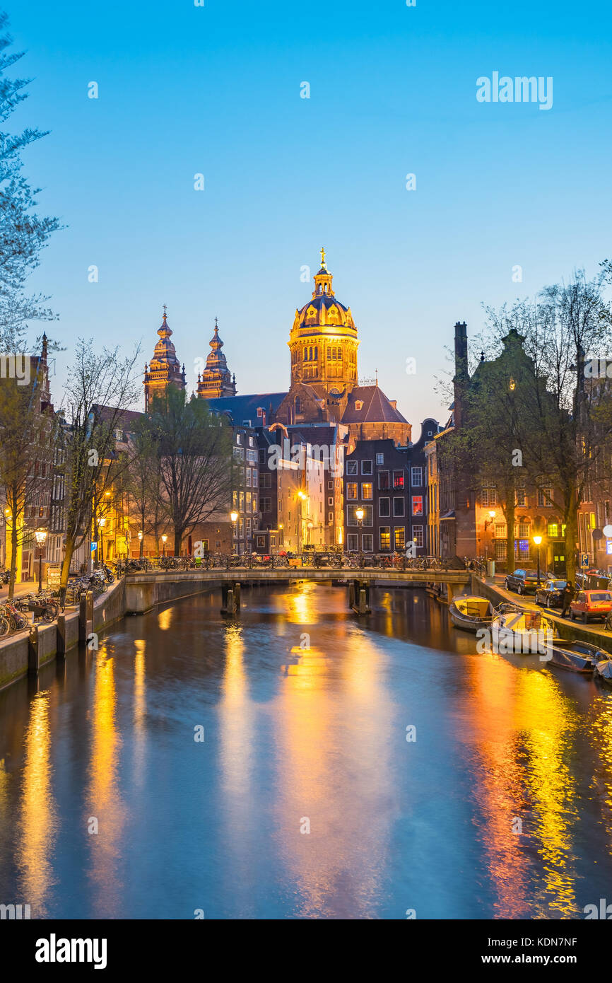 Noche en Amsterdam, con la basílica de San Nicolás en la ciudad de Amsterdam, Holanda. Foto de stock