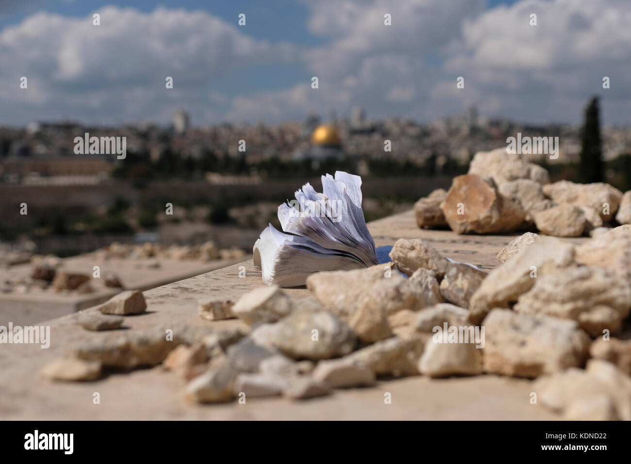 Un libro de oración y pequeños pedazos de piedra se ven sobre una tumba