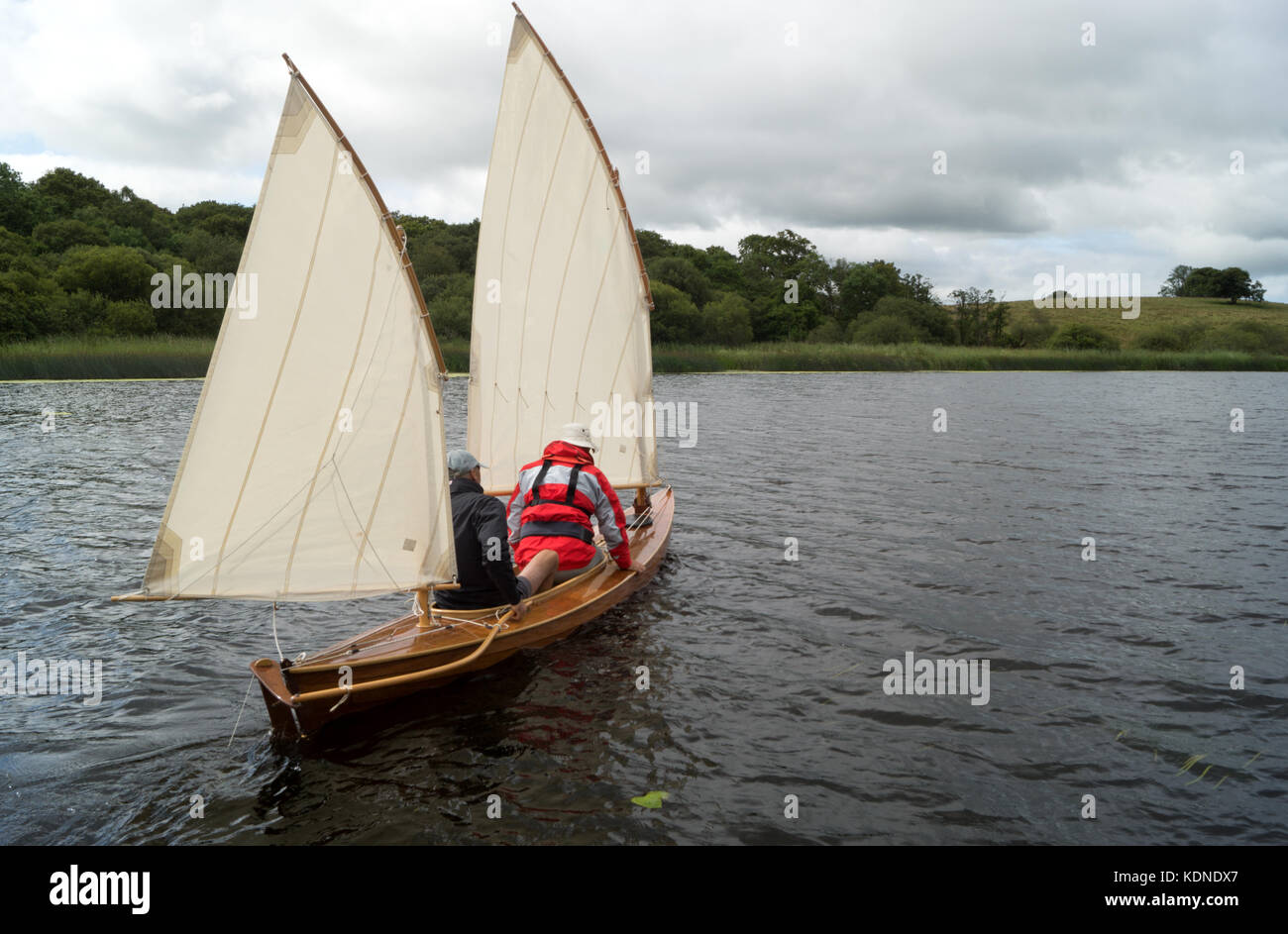 Frotar temor Consistente Velero canoa en el río, con dos velas, navegar lejos con dos hombres a  bordo Fotografía de stock - Alamy