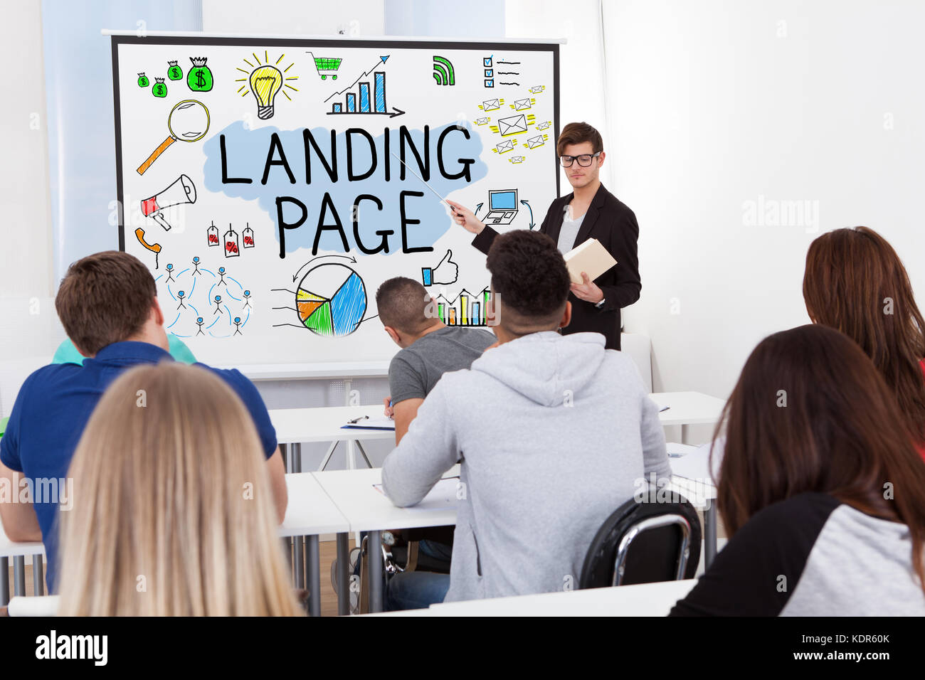 Maestro explicando el concepto de landing page para los estudiantes en el aula Foto de stock