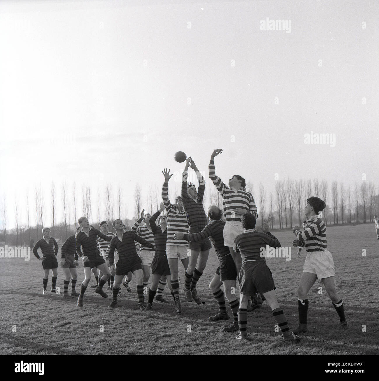 1960, histórica, la imagen muestra un rugby amateur match y la reenvía los dos equipos compitiendo por el balón en una salida de línea, Inglaterra, Reino Unido. Foto de stock