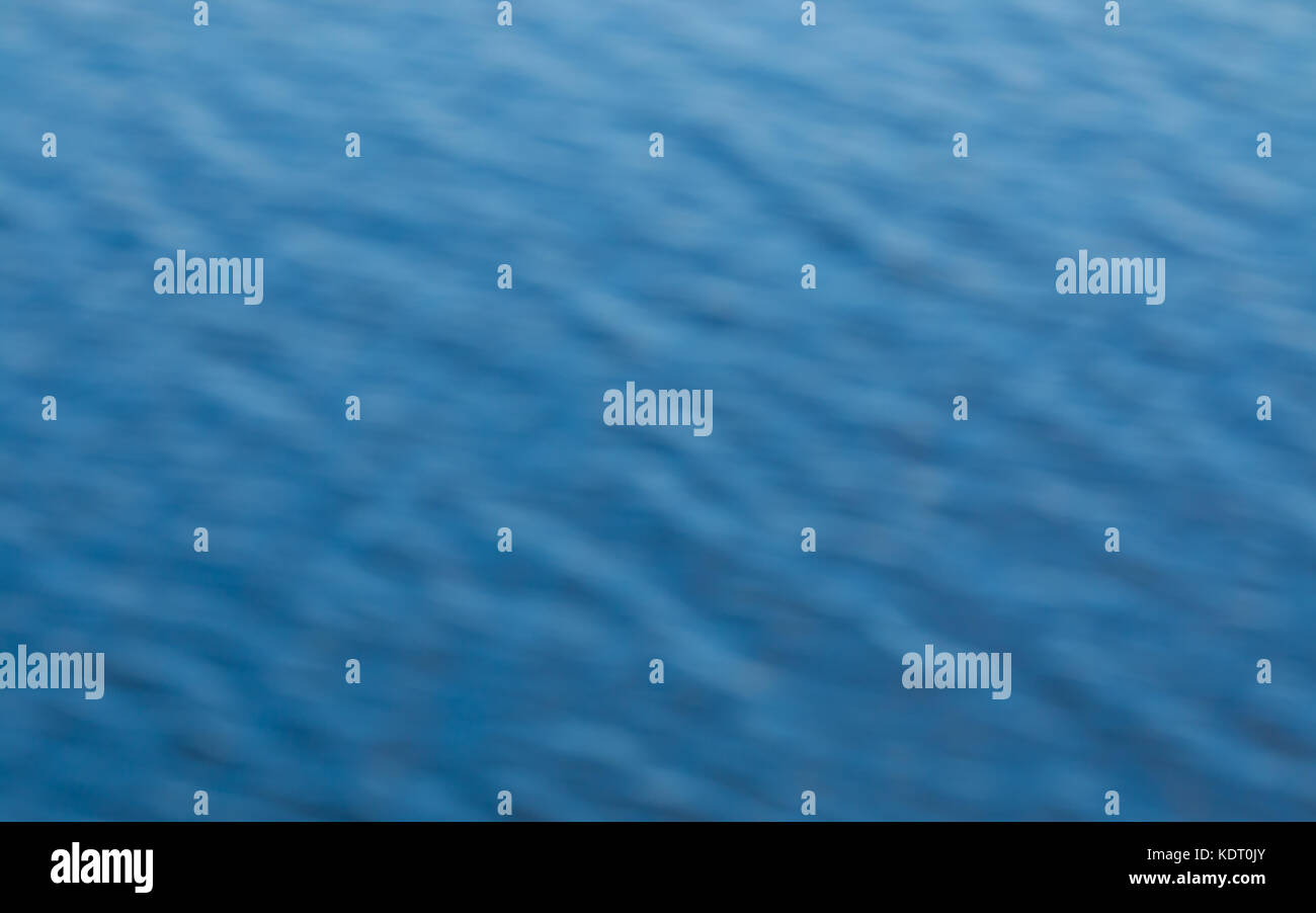 Fondo difuminado de olas en el océano azul que muestra el patrón de onda de textura suave. Foto de stock