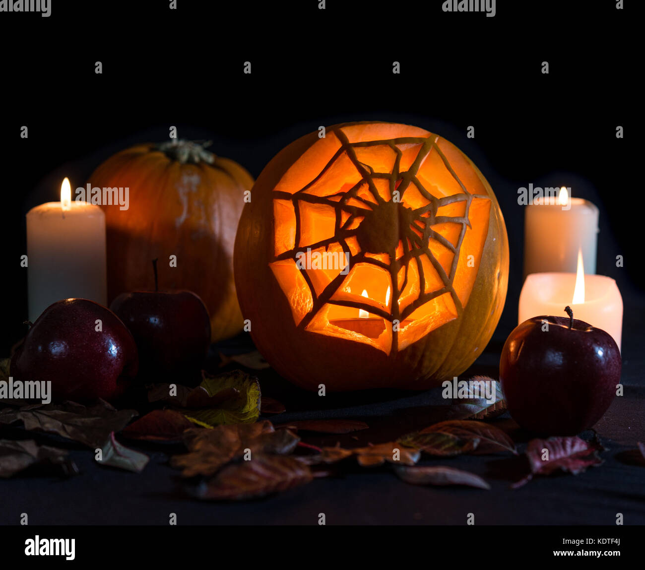 La Araña de & web calabaza tallado con manzanas y velas Foto de stock