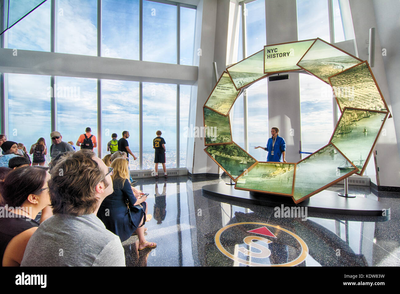 Un guía turístico, educa a los turistas visitantes sobre la historia de la ciudad de Nueva York en un observatorio mundial, en el World Trade Center, New York, NY, EE.UU. Foto de stock