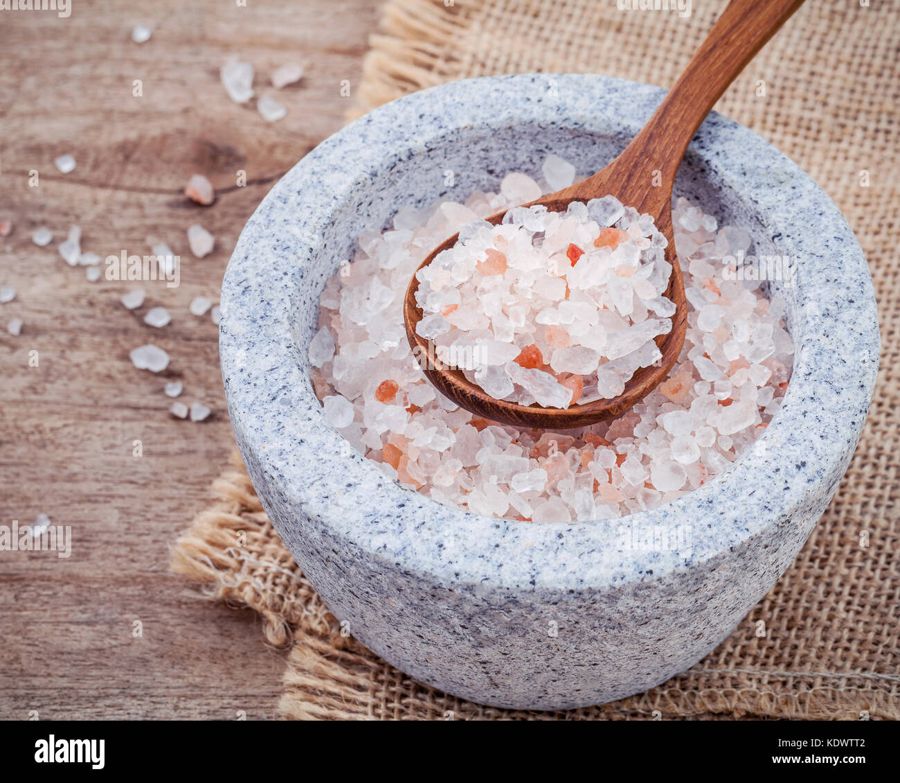 Sal rosa del Himalaya en el mortero en fondo de saco de cáñamo. Himalayan  Salt comúnmente utilizado en la cocina y baño para productos tales como  sales de baño Fotografía de stock -