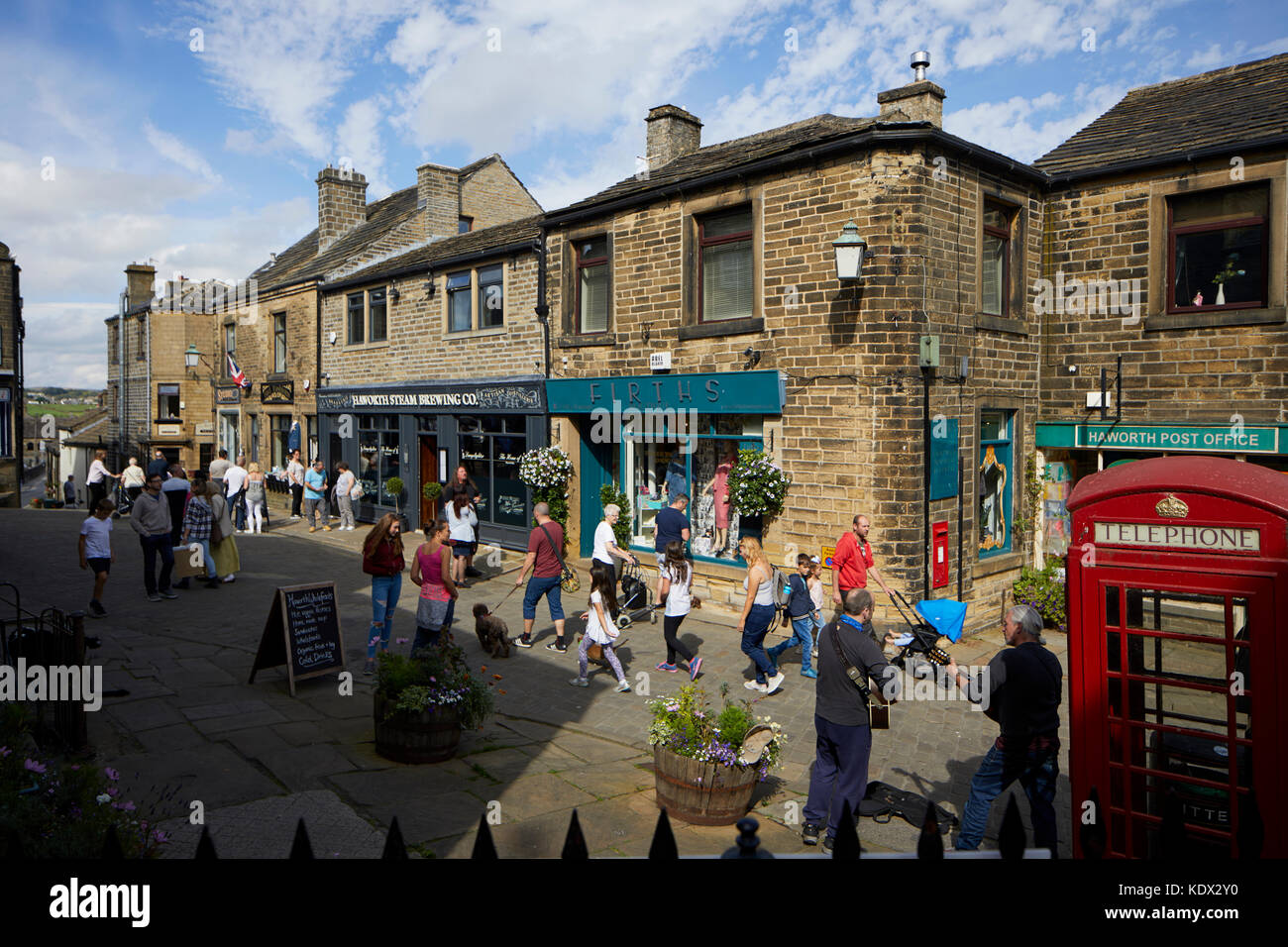 Los Peninos village, Haworth en West Yorkshire, Inglaterra. terrazas de casas y negocios en la empinada calle principal Foto de stock