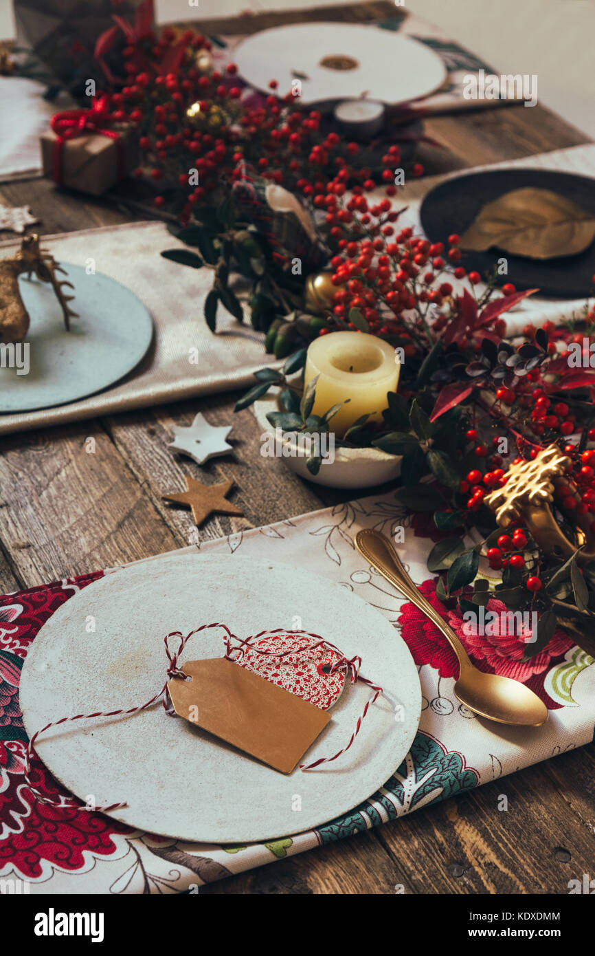 Ajuste de la tabla de navidad rústica con vajilla de cerámica artesanal  vacía, platos y cuencos, decoraciones de ángel de navidad, vasos, ramas  verdes sobre mantel blanco