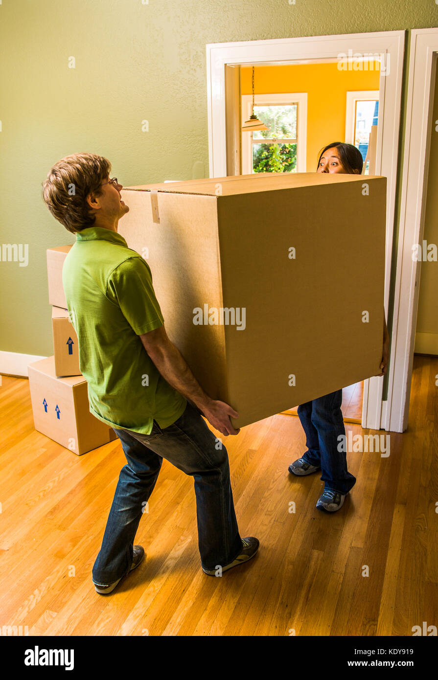 Una pareja lleva una caja grande como si entrando o saliendo de una casa  Fotografía de stock - Alamy