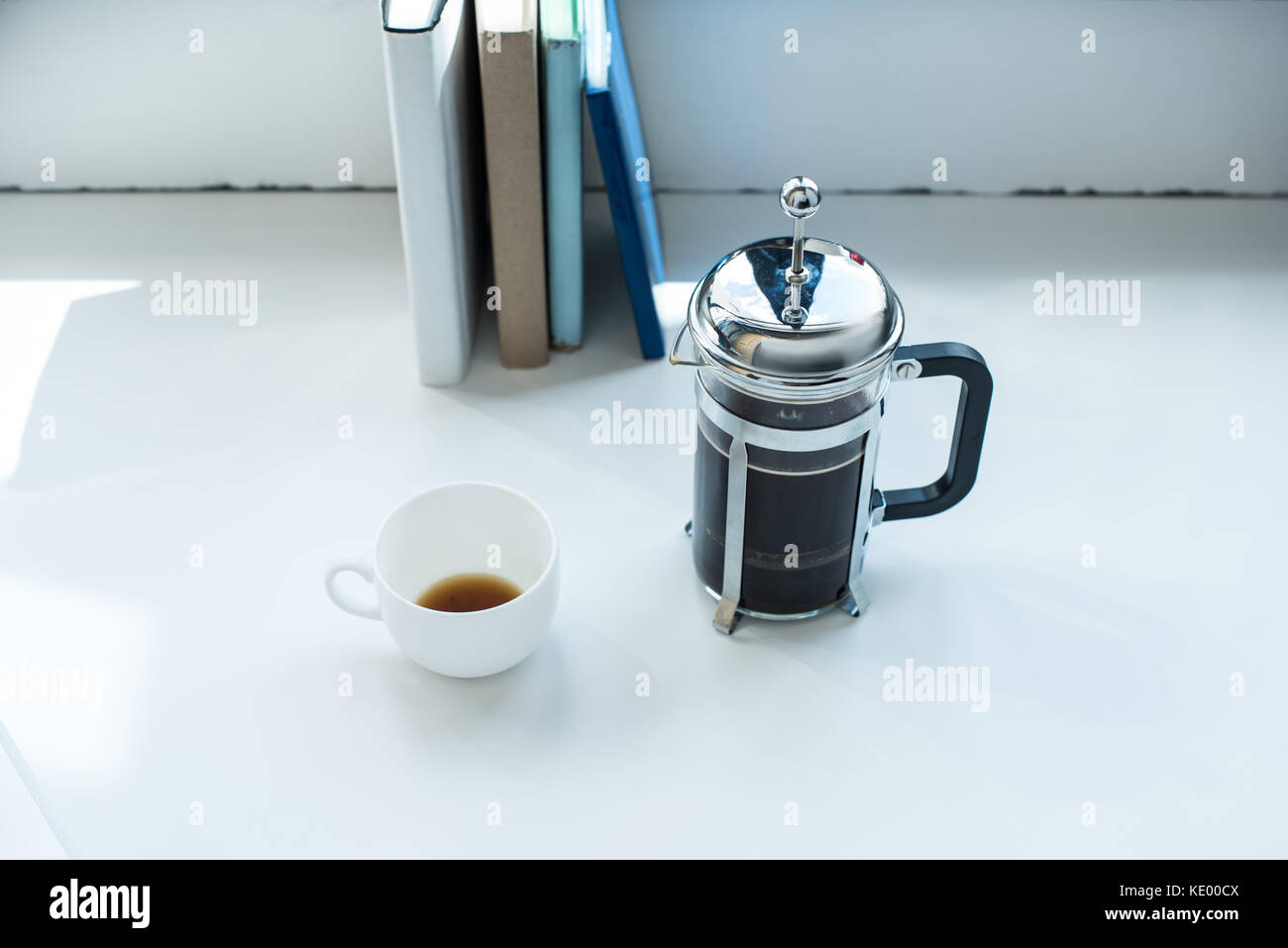Prensa francesa con la taza de café de pie en blanco escritorio con fila de  libros Fotografía de stock - Alamy