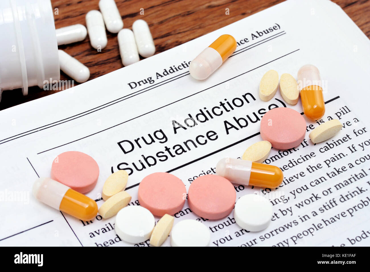 Información sobre la adicción a las drogas o el abuso de sustancias con píldoras varius esparcidas por la página. Primer plano macro. Foto de stock