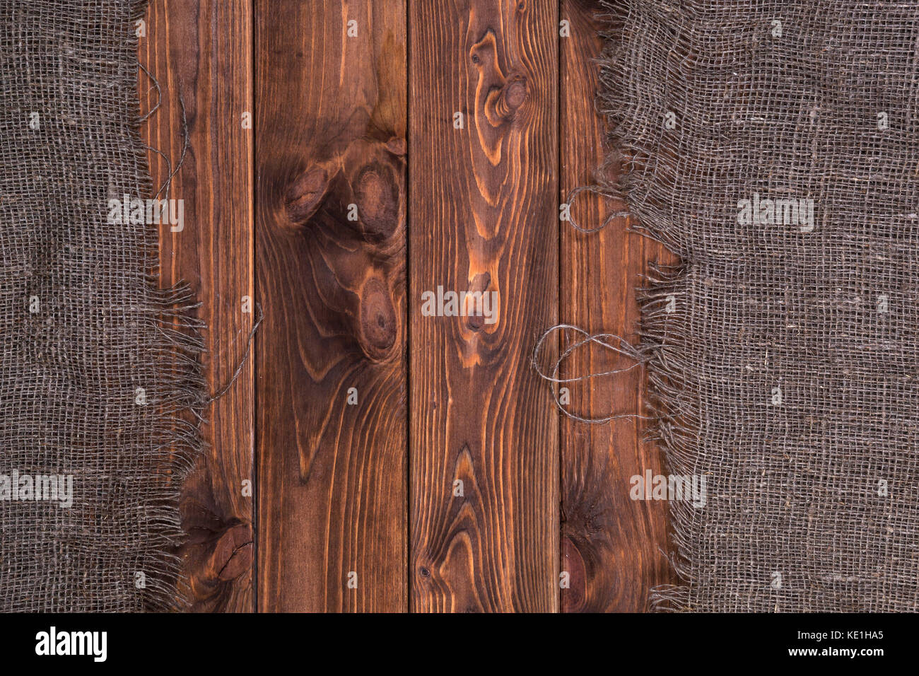 La arpillera sobre fondo de madera oscura, vista superior Foto de stock