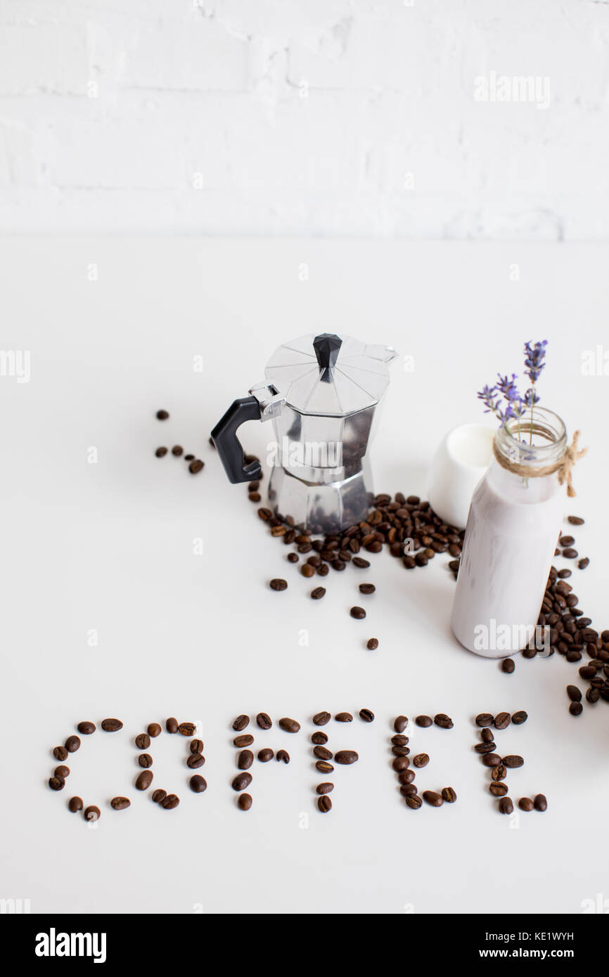 Prensa francesa, una jarra de leche y bebida de lavanda salpicado de granos  de café y café de Word en el cuadro blanco Fotografía de stock - Alamy