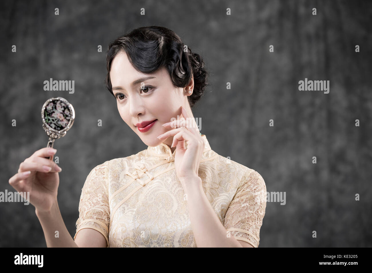 Retrato de joven mujer sonriente en estilo retro ropa oriental posando con espejo Foto de stock