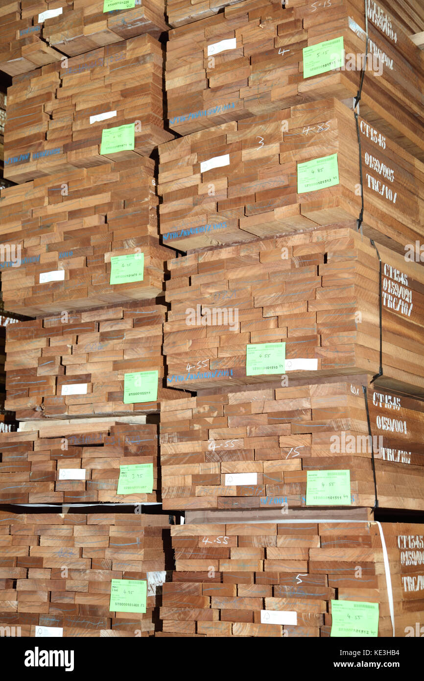 Tablas de madera dura importadas apiladas en un moderno almacén de