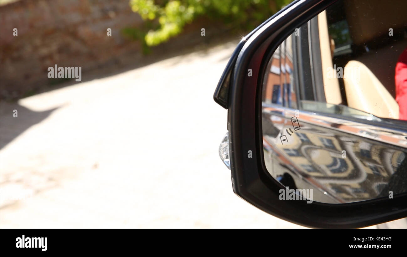 Sistema de monitoreo de punto ciego Icono de luz de advertencia en el espejo de vista lateral de un vehículo moderno. sistema de puntos ciegos del coche Foto de stock