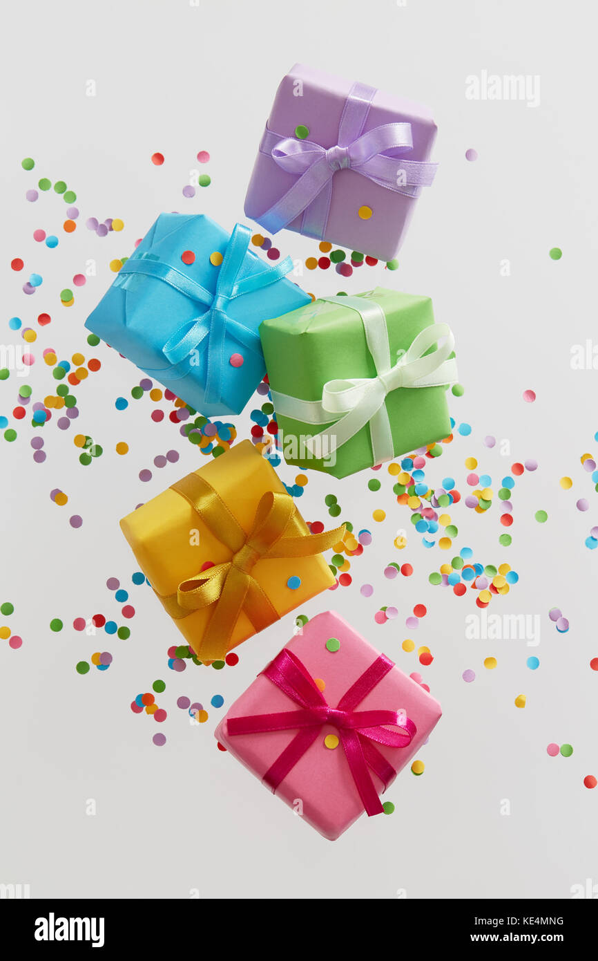 Cajas de regalo de colores con confeti cayendo o volando en movimiento  Fotografía de stock - Alamy