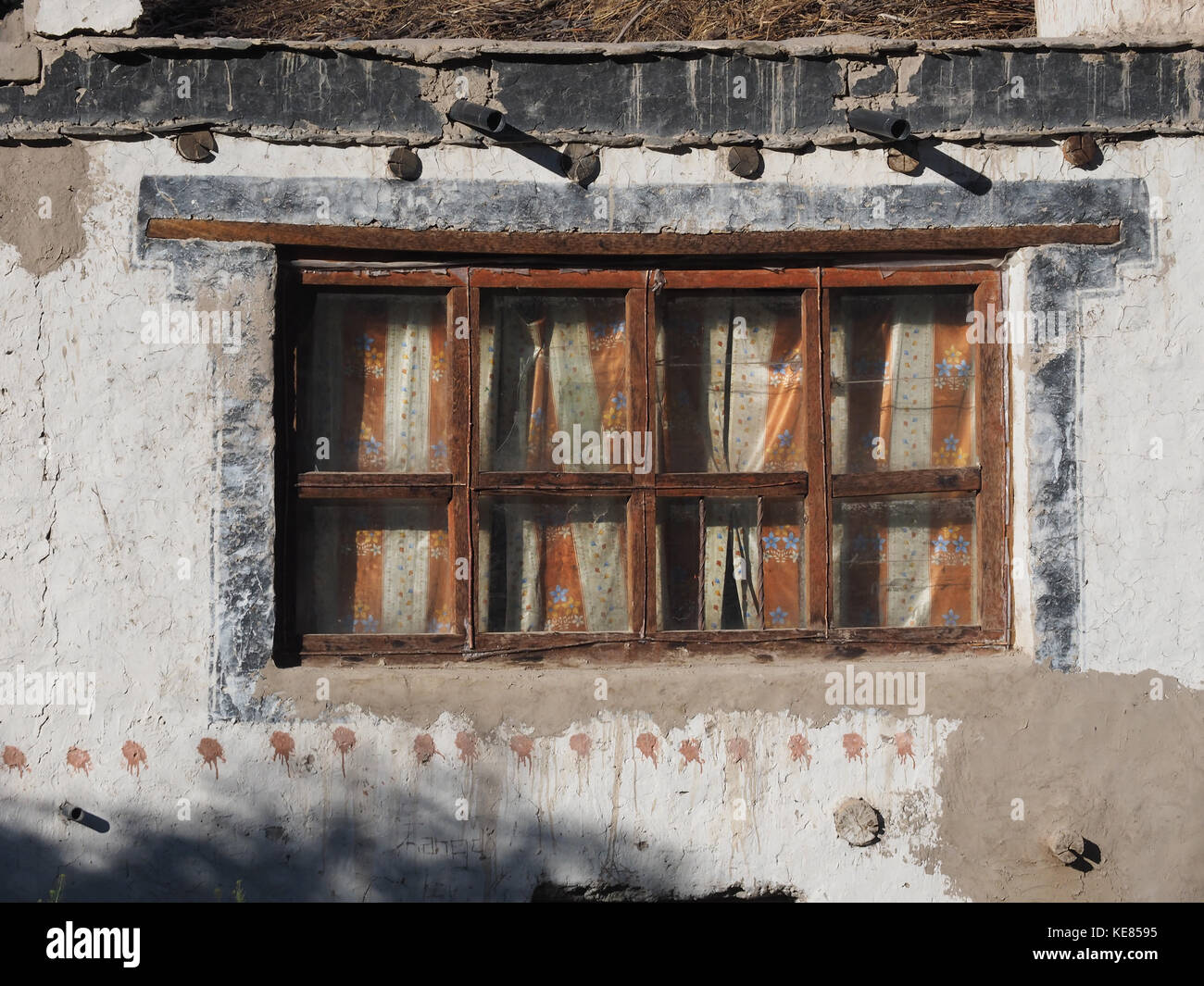 Vintage de la ventana de una casa rural: antiguo de madera marrón de marcos,  a través de las cortinas de tela de fibra de vidrio son visibles, pared de  arcilla blanca Fotografía