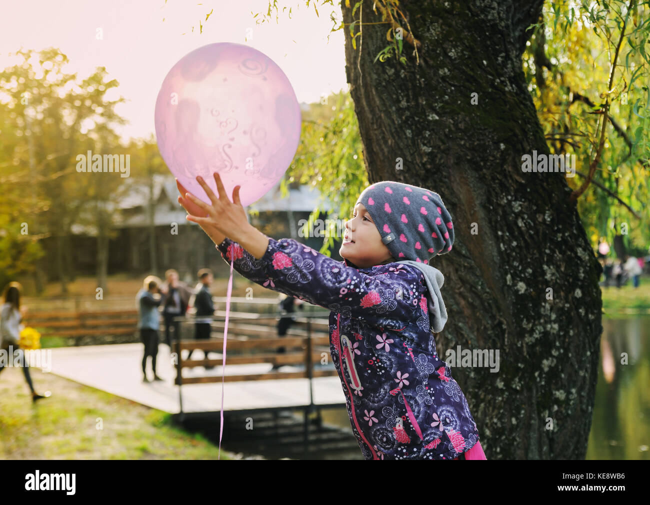 Elegante niña 4-5 años de celebración gran globo vistiendo la moda vestido  rosado en la pradera. Juguetón. Fiesta de cumpleaños. niña con un globo en  el par Fotografía de stock - Alamy